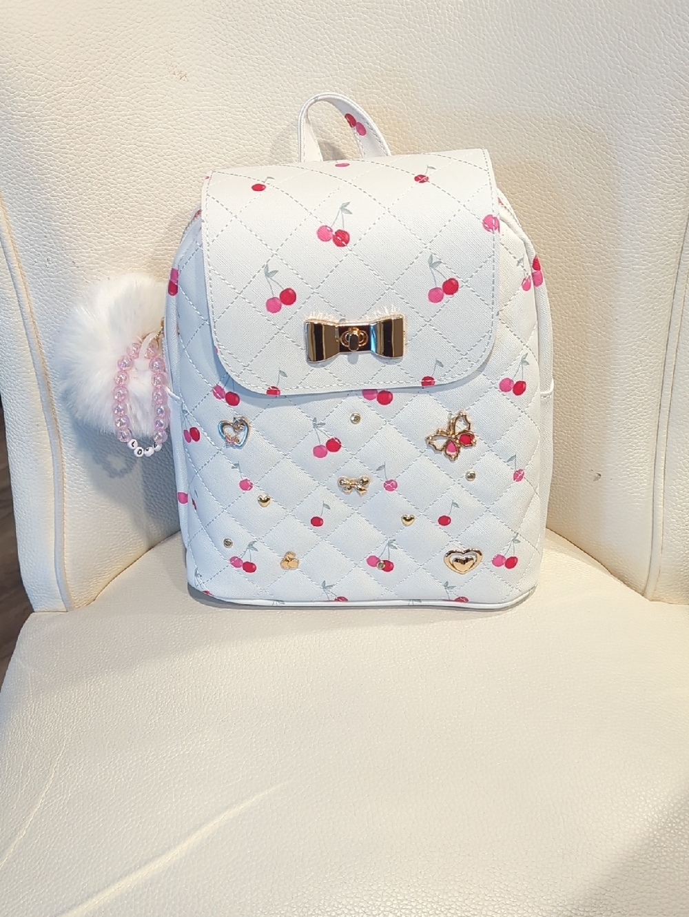 Under One Sky White Quilted Cherry Print Mini Backpack with Gold Bow Accent